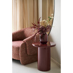 Table d'appoint Otago bordeaux brillant avec vase fleurs près fenêtre arquée salon lumière naturelle