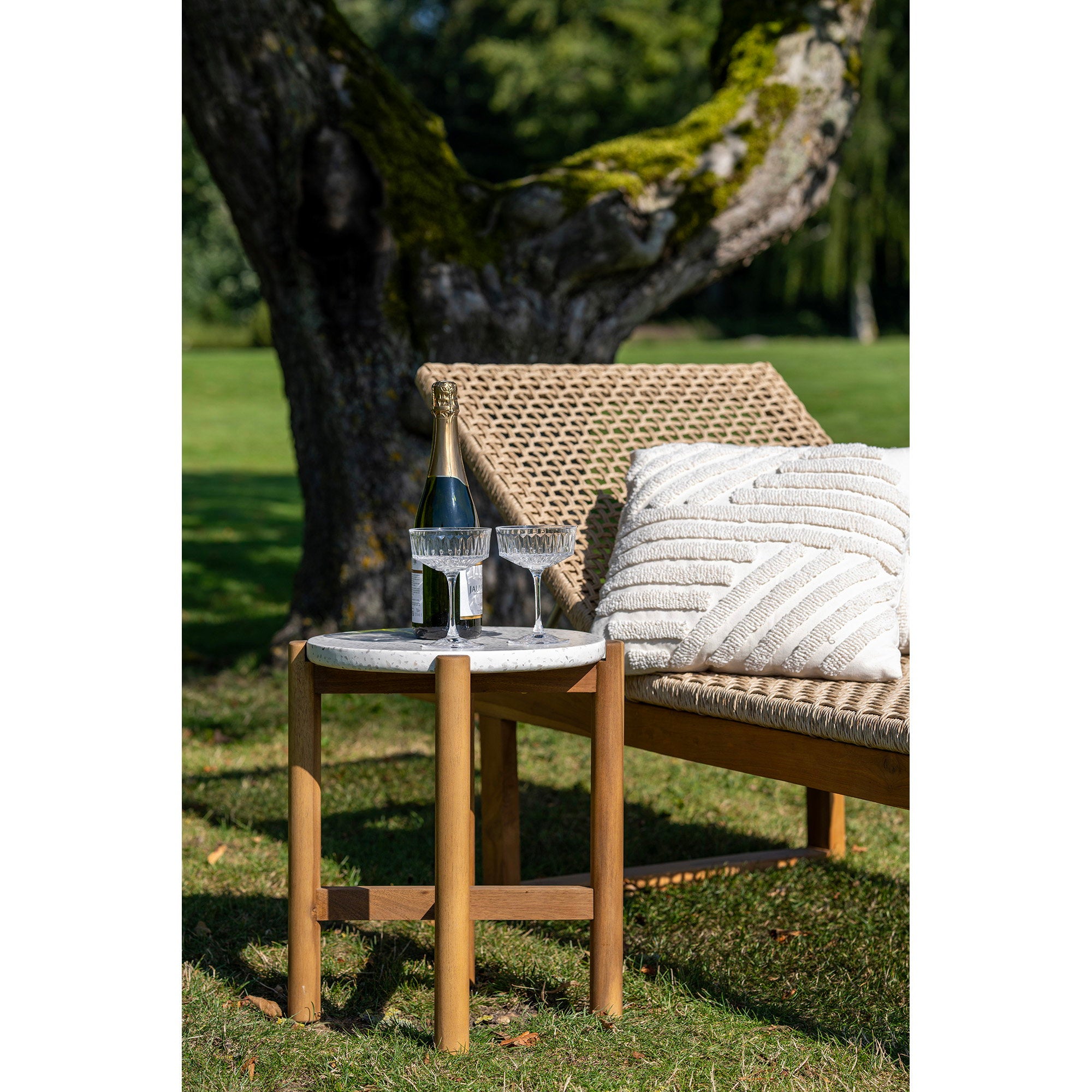 Table d'appoint Terracina terrazzo acacia en situation jardin avec chaise longue et champagne