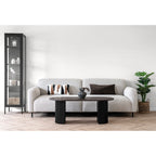 Table basse Boavista brun foncé en situation salon canapé blanc bouclé vitrine noire