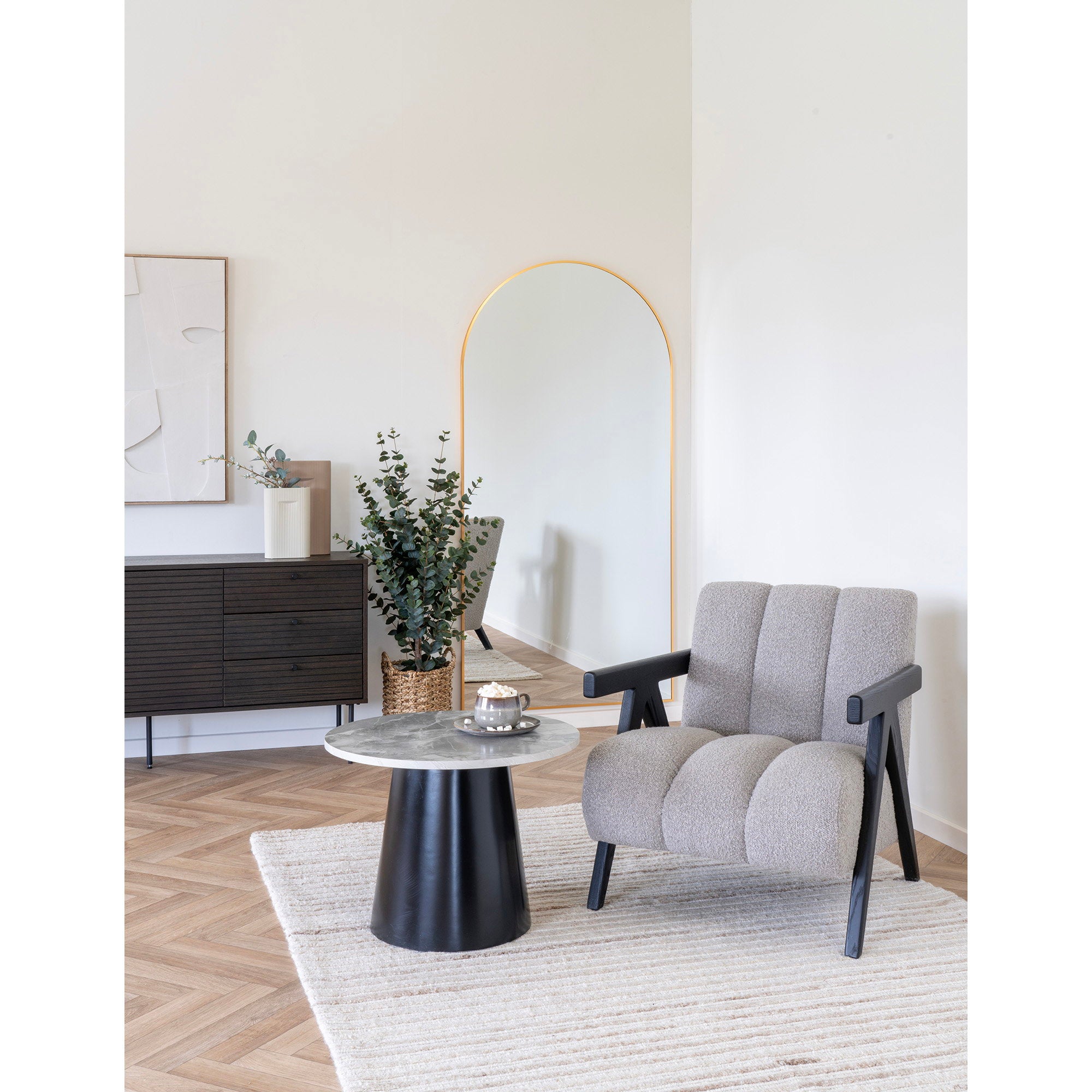 Table basse Brito marbre gris noir en situation salon fauteuil bouclé miroir doré