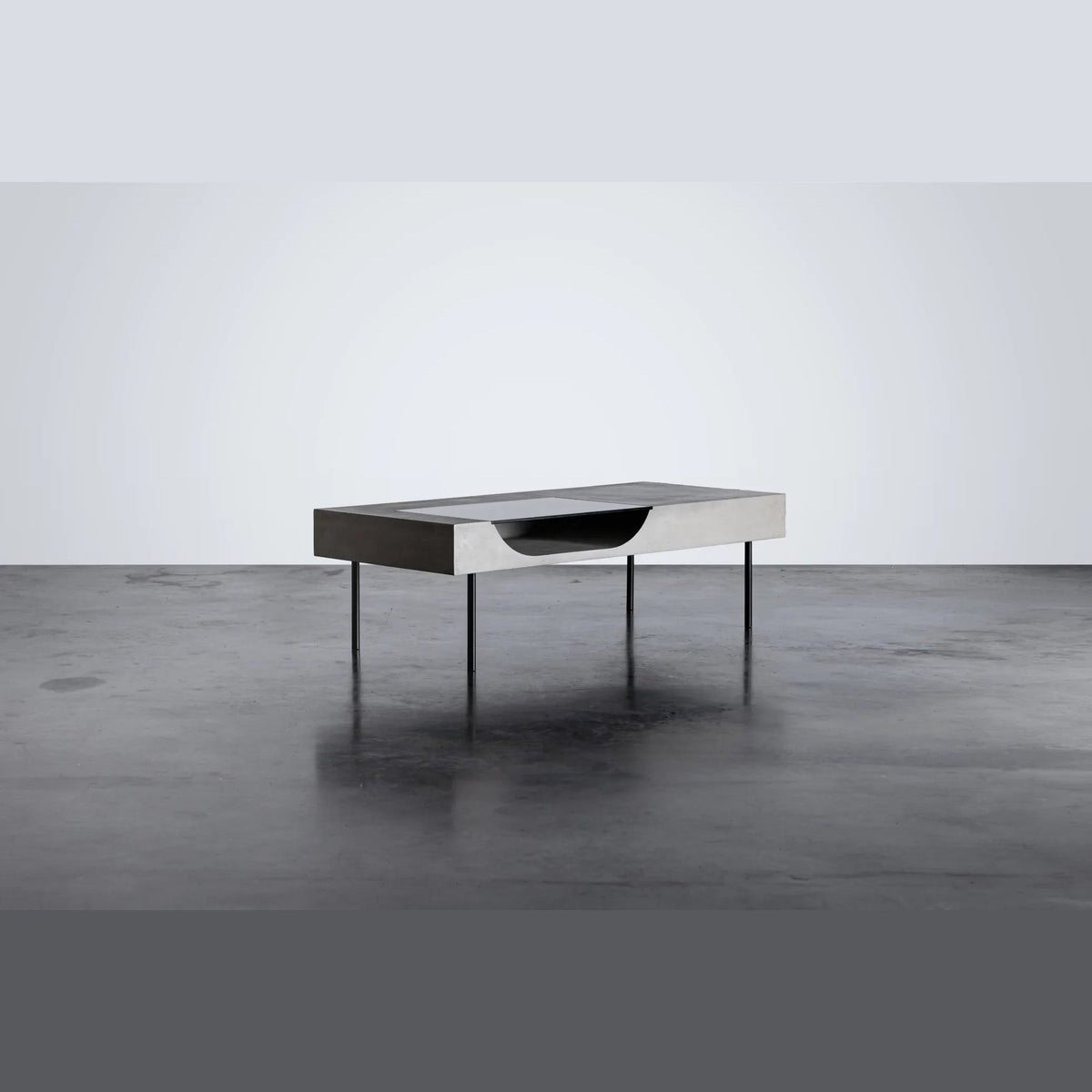 Table basse Curb en béton vue de trois quarts avec ses quatre pieds fins en acier noir