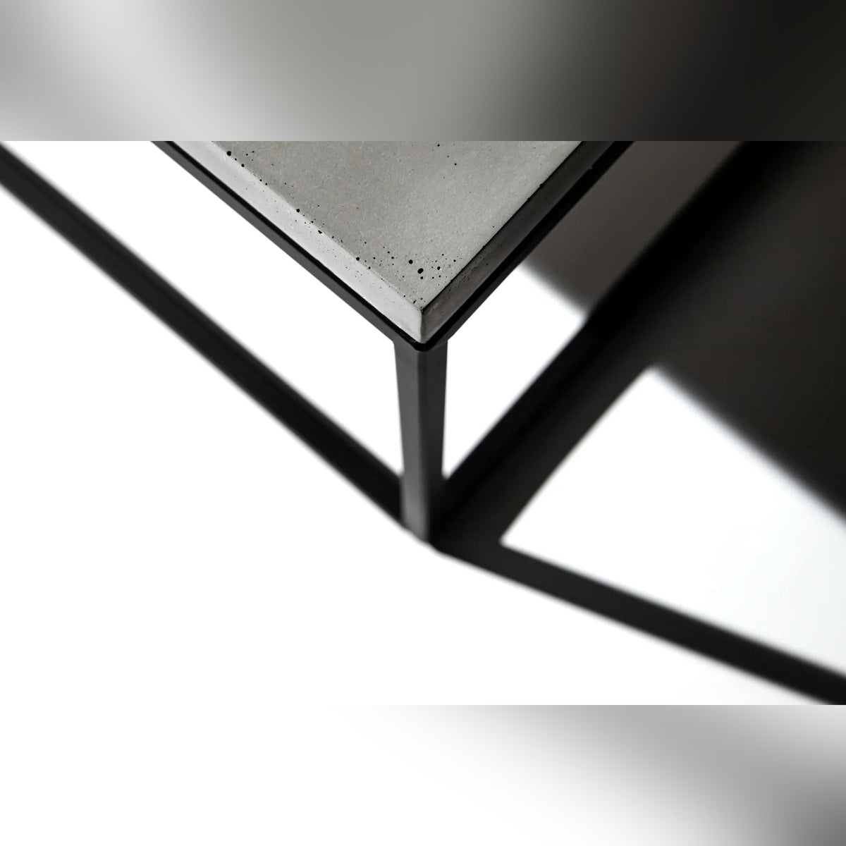 Angle du plateau en béton posé sur le cadre en acier noir de la table Perspective