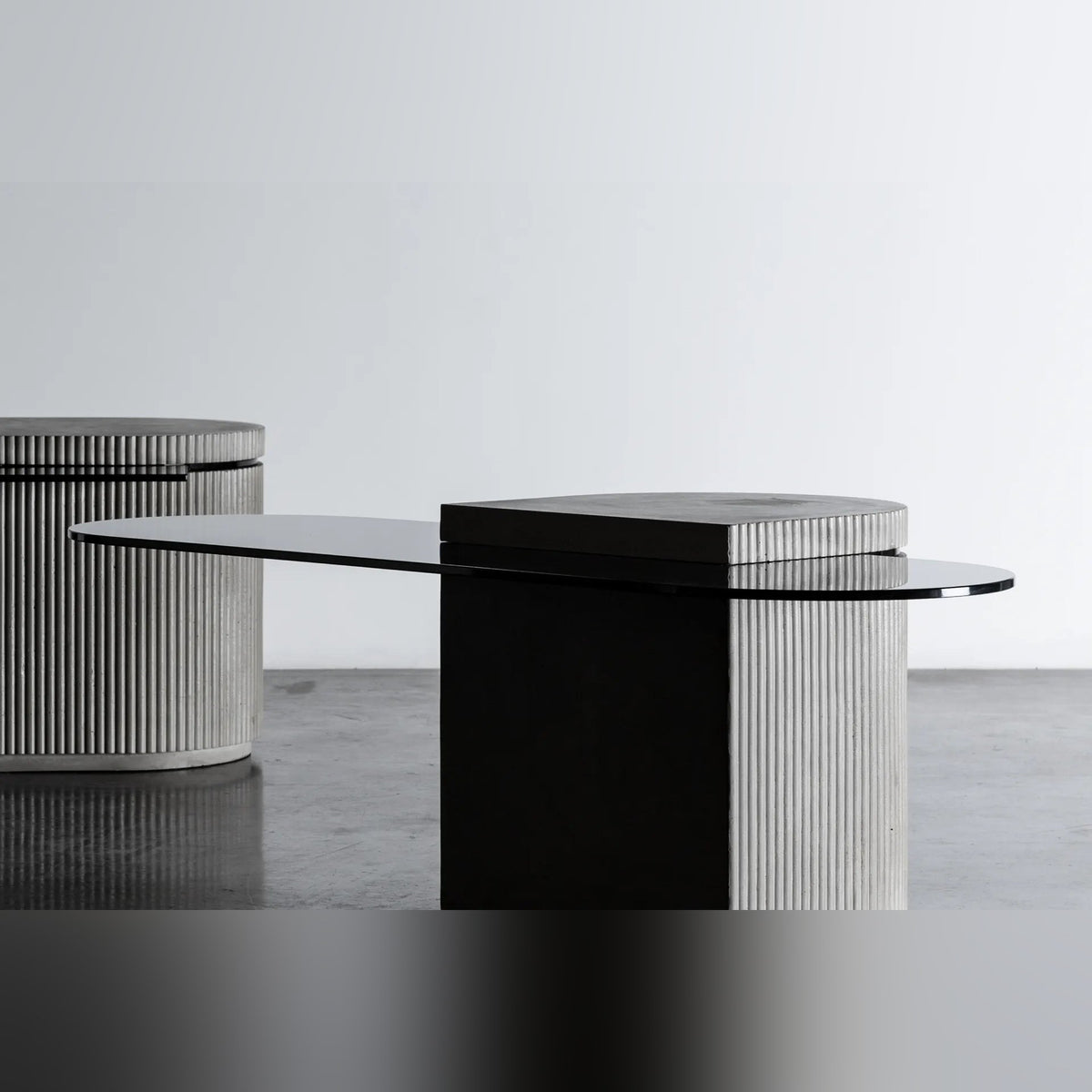 Table basse Strut oblongue au premier plan avec son plateau en verre teinté et une autre table Strut en arrière-plan