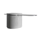 Table basse Strut oblongue avec son pied en béton cannelé et son plateau en verre teinté en forme de pilule