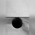 Vue de dessus du bord du plateau en béton gris et de l'extrémité ronde d'un pied noir