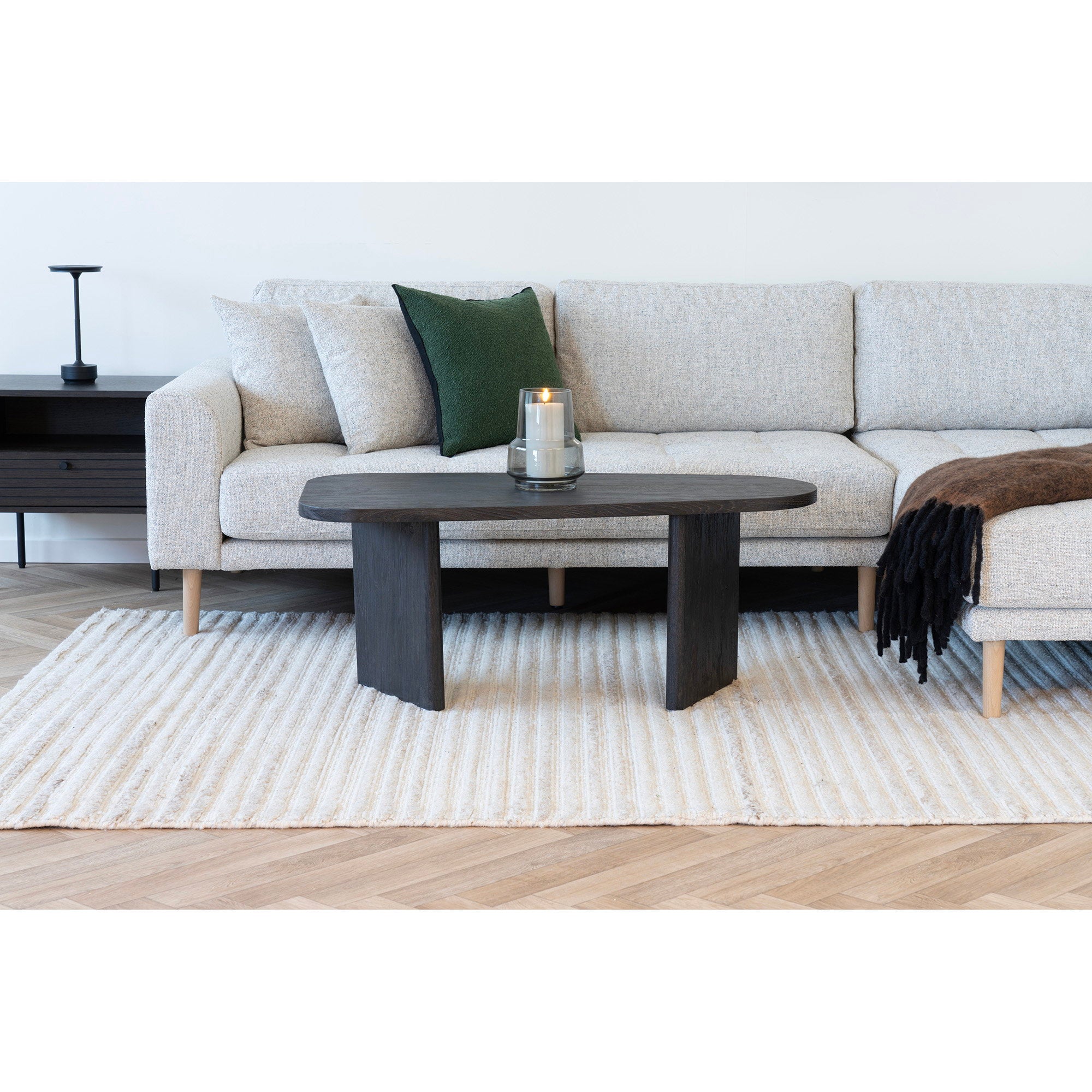 Table basse Melo brun foncé en situation salon canapé d'angle beige bouclé tapis rayé