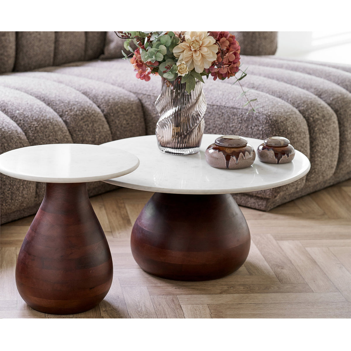 Table basse Heide et table d'appoint Heide côte à côte avec un vase en verre et deux pots à couvercle