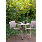 Table Barletta entre deux fauteuils de jardin à accoudoirs sur une terrasse en briques