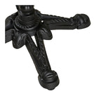 Gros plan sur la base en fonte noire à quatre branches sculptées en relief et sur un patin vissé