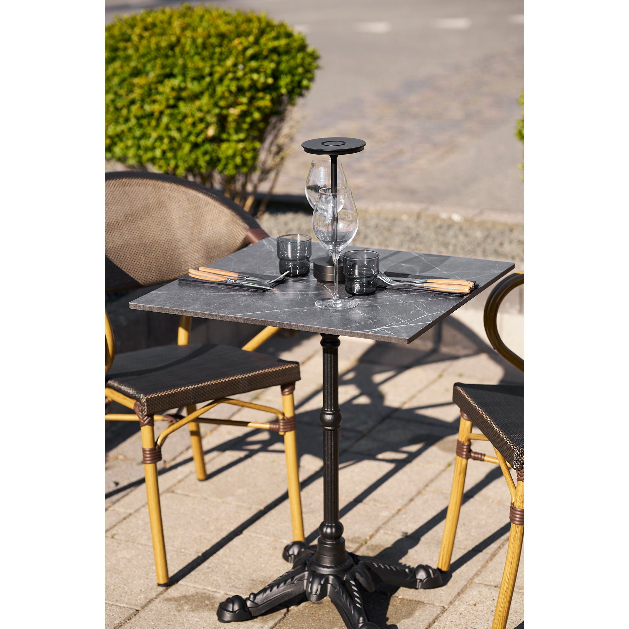 Table bistrot carrée marbre noir dressée verres à vin terrasse extérieure style parisien