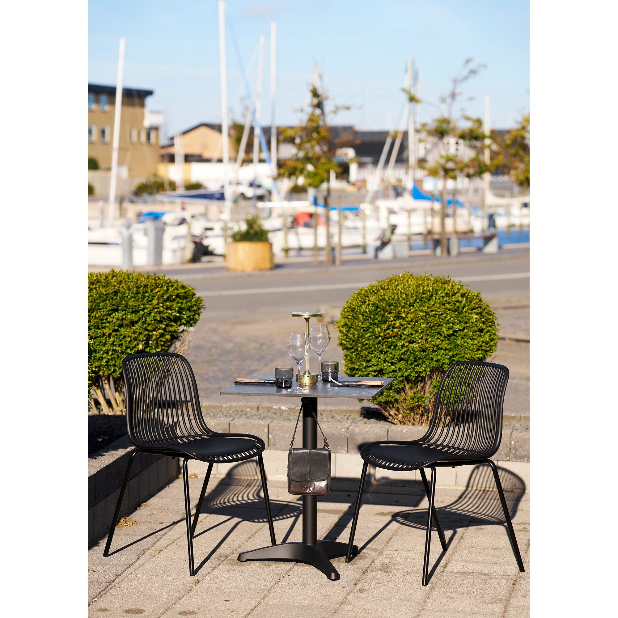 Table bistrot marbre noir aluminium terrasse port chaises noires filaires dressage outdoor