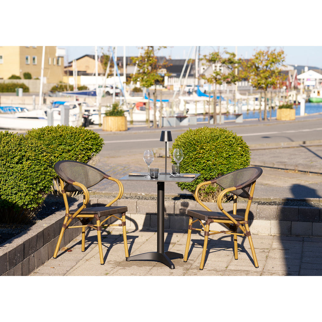 Table bistrot marbre noir aluminium en situation terrasse bord de mer chaises bistrot rotin
