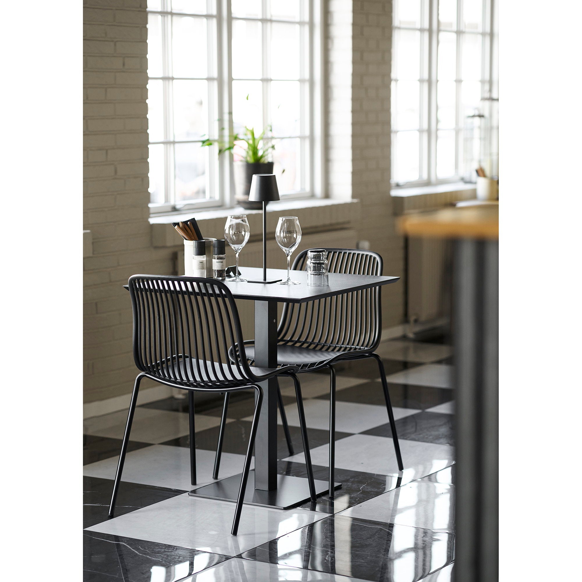 Table café Fano effet pierre anthracite avec chaises noires ambiance restaurant monochrome