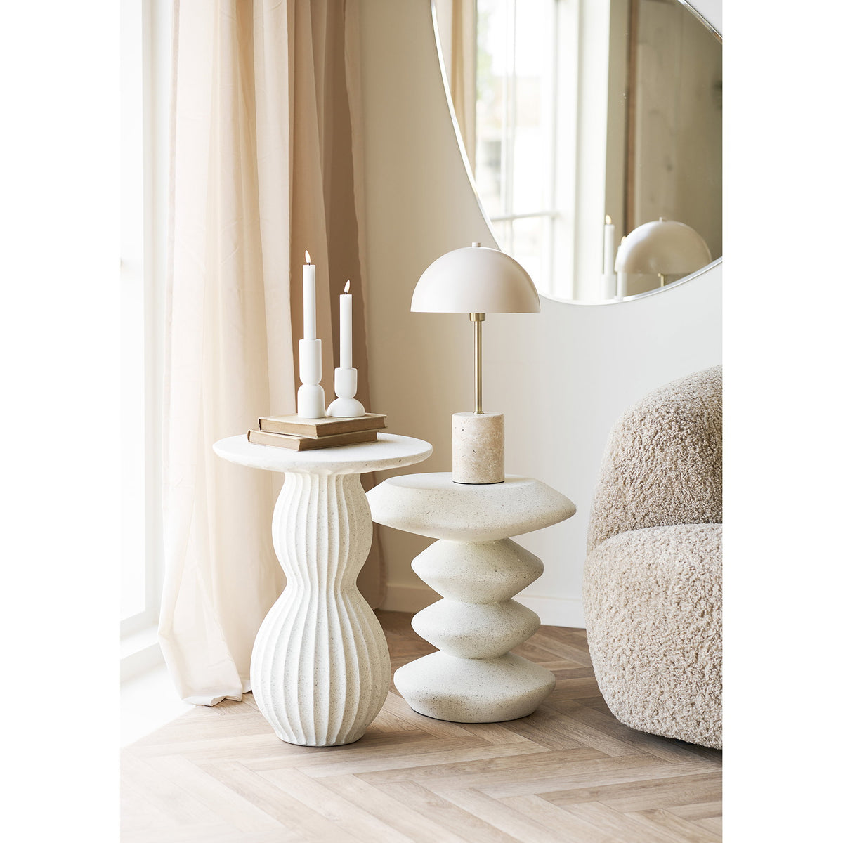 Table d'appoint Blackburn avec une lampe à côté d'une table d'appoint côtelée blanche portant des bougies