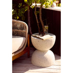 Table d'appoint Bonita effet terrazzo avec un livre ouvert des lunettes de soleil et un verre sur une terrasse