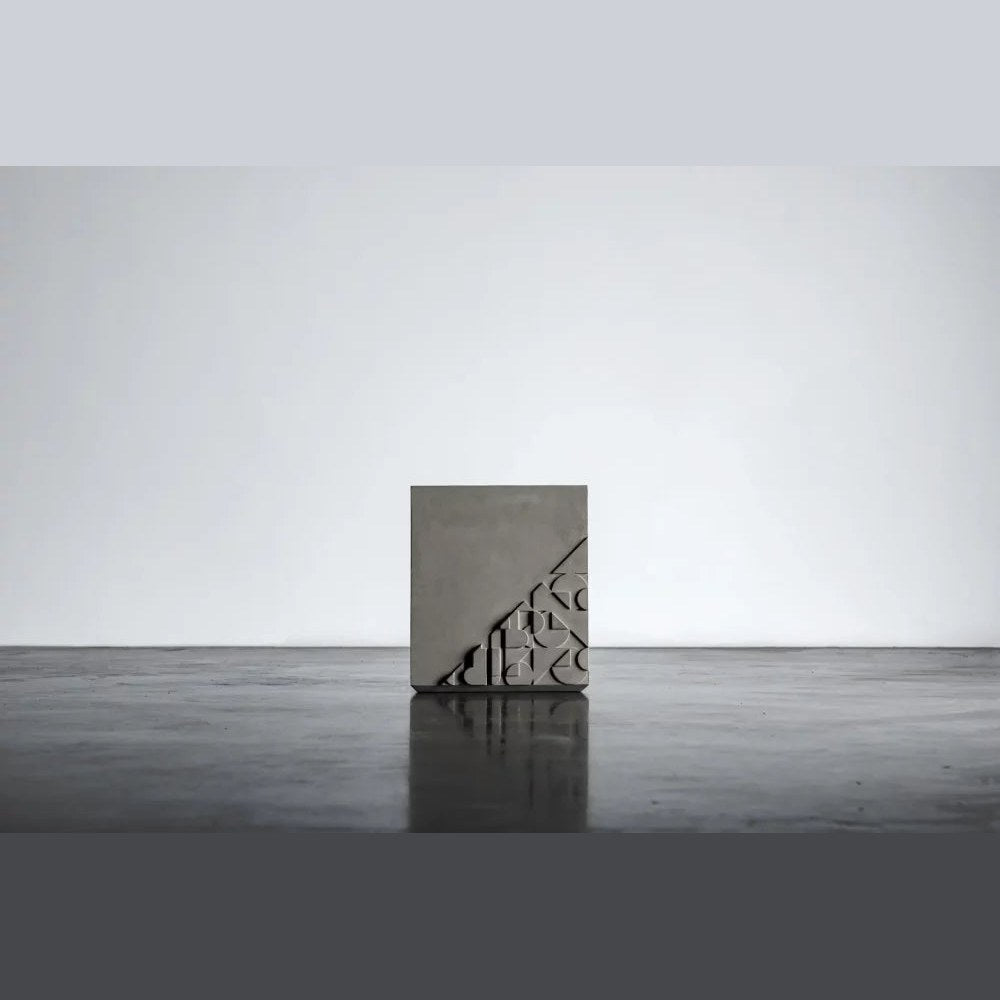 Table d'appoint Curb en béton vue de face sans son globe avec le motif en bas-relief