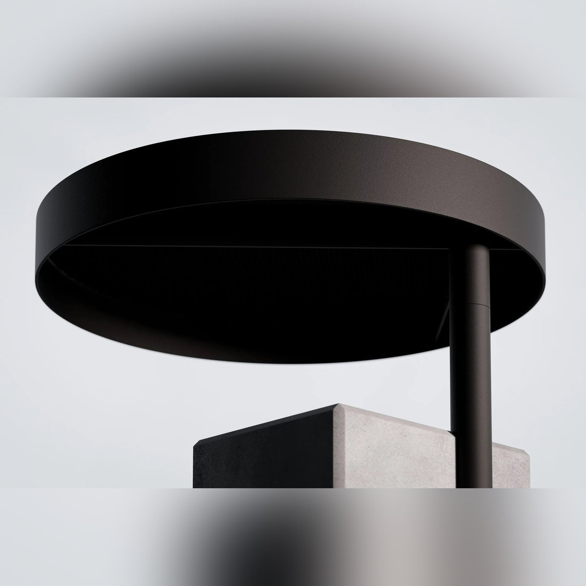 Dessous du plateau rond noir de la table d'appoint Twist et haut de sa base en béton