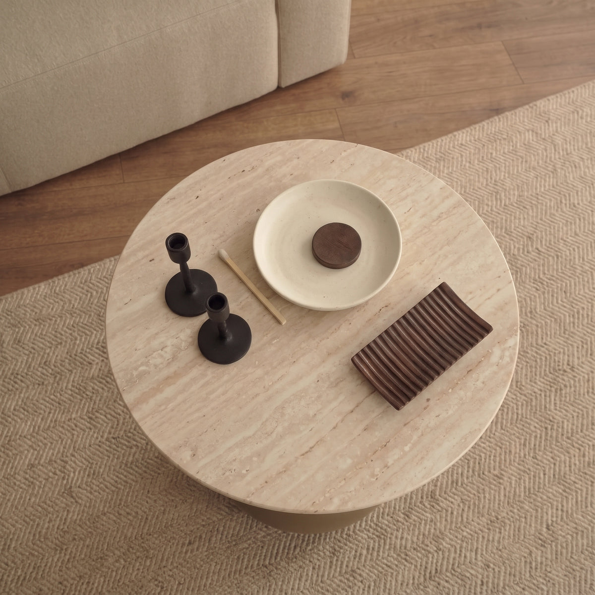Plateau en verre effet travertin de la table d'appoint Pienza vu d'en haut, avec deux bougeoirs noirs, une coupelle et un vide-poche en bois rainuré