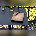 Plateau en aluminium noir de la table Donut rectangulaire avec une planche en bois un couteau et une carafe