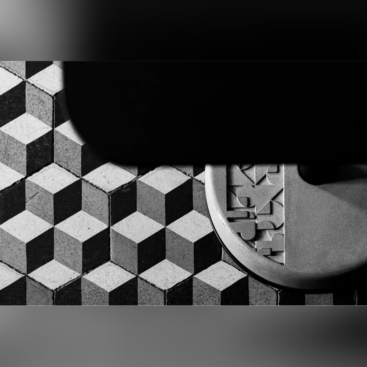Vue de dessus du socle en béton à motif en relief de la table Donut sur des carreaux de ciment à cubes