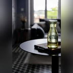 Carafe et planche en bois sur le plateau noir de la table de bistro Donut dans un salon