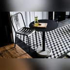 Table de bistro Donut ronde et chaise en métal sur un sol de carreaux à motif de cubes