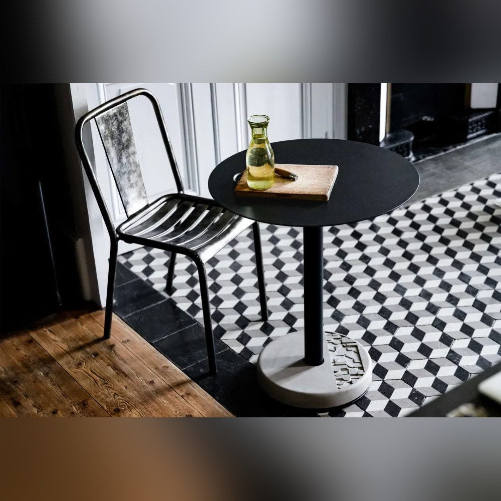 Table de bistro Donut ronde et chaise en métal sur un sol de carreaux à motif de cubes