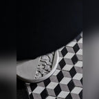 Socle en béton à motif en relief de la table Donut sur un sol de carreaux à cubes noirs et gris
