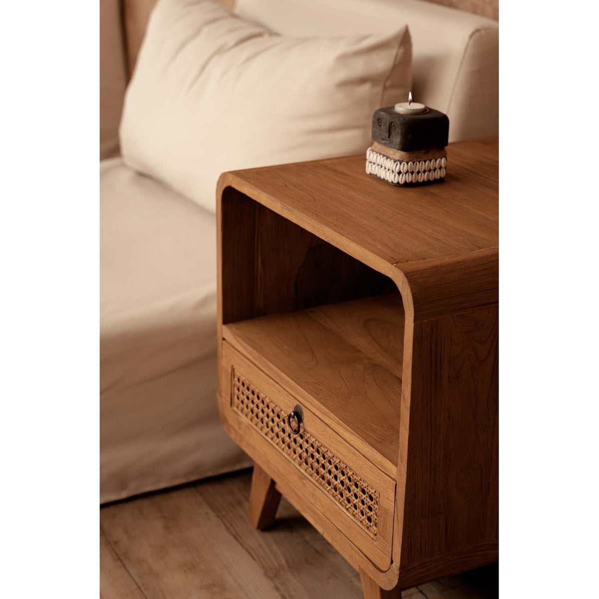 Table de chevet Breeze vue de trois quarts près d'un lit avec un bougeoir posé sur son plateau