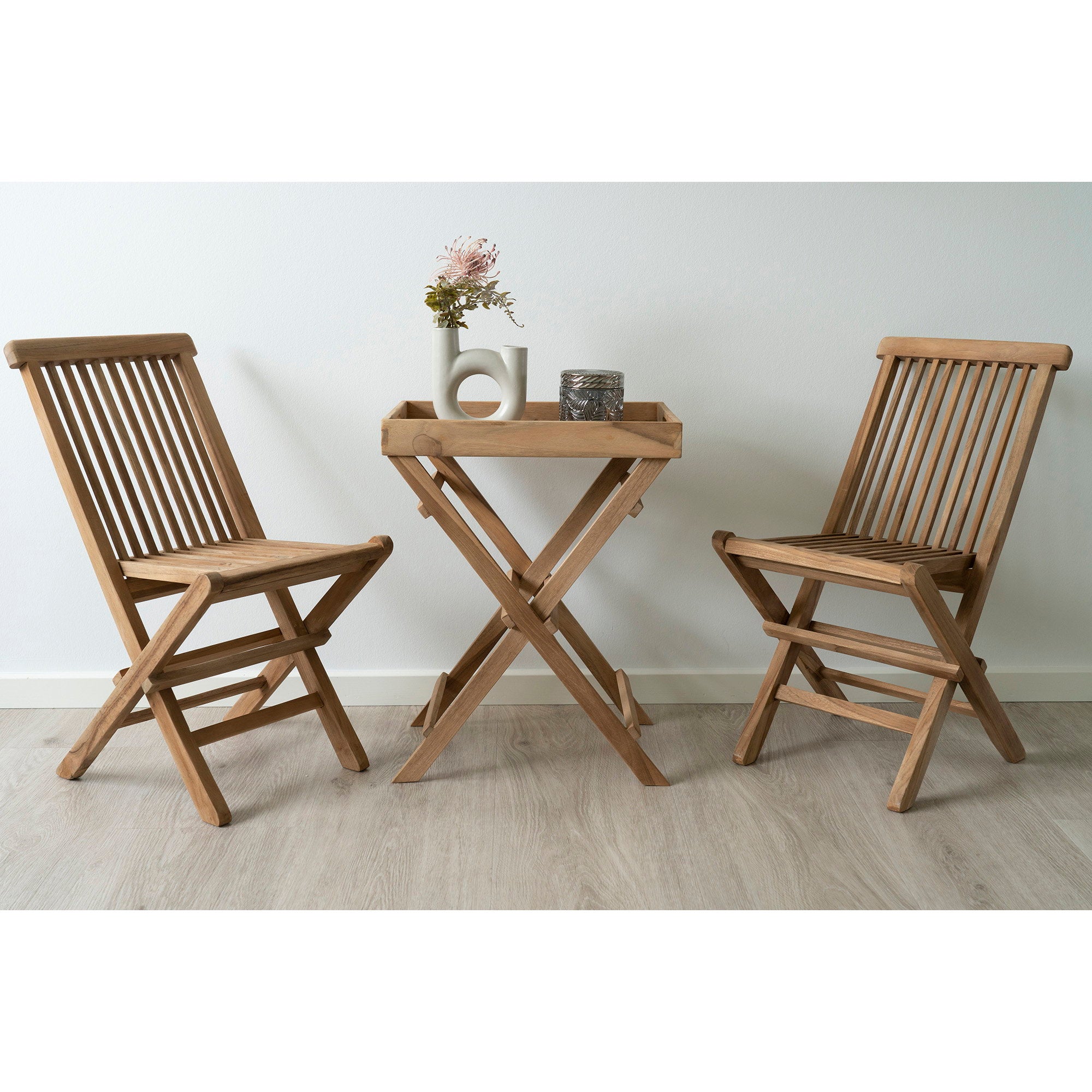 Table plateau teck Ronda compacte entre deux chaises pliantes teck en intérieur