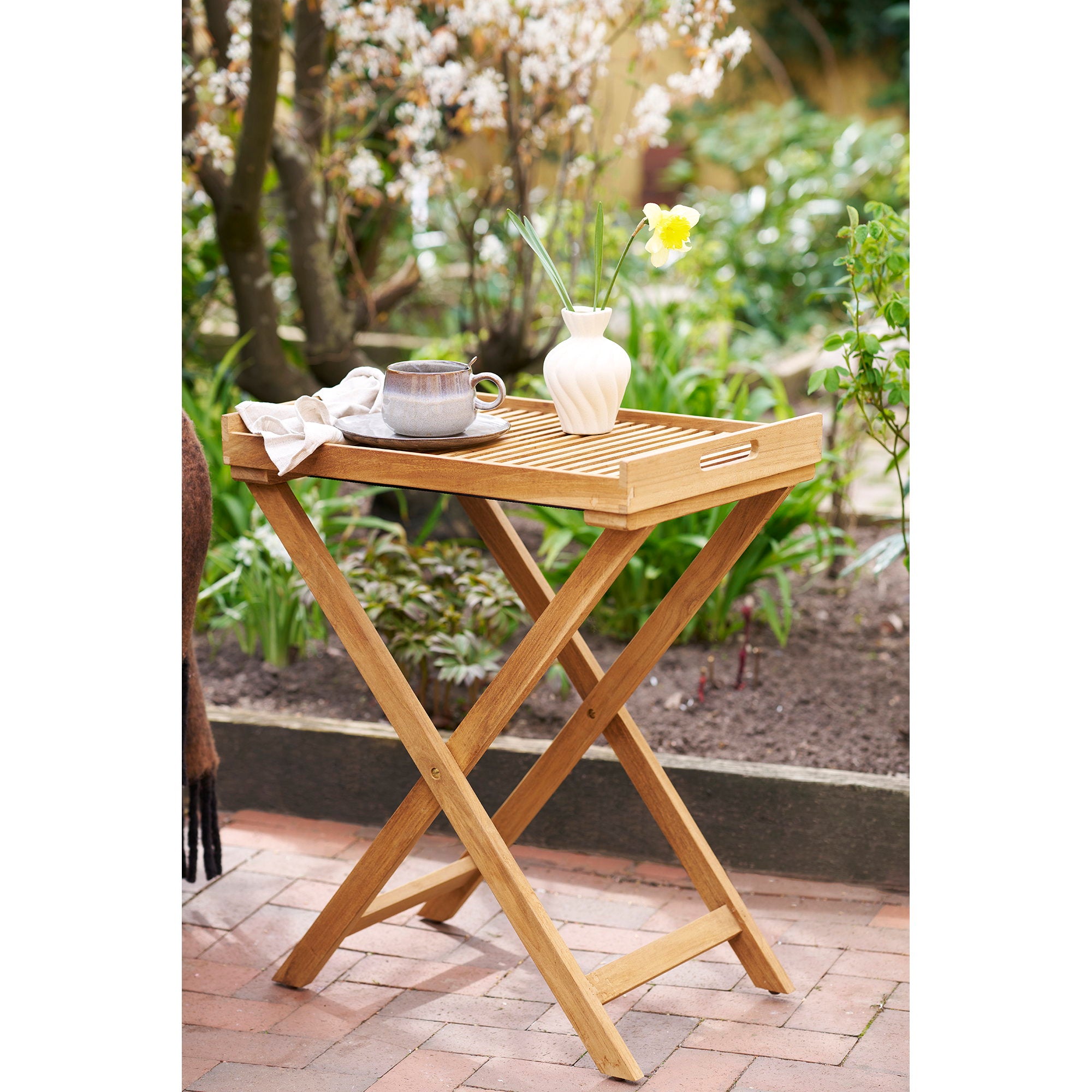 Table plateau teck Ronda sur terrasse de jardin avec tasse café et vase fleur