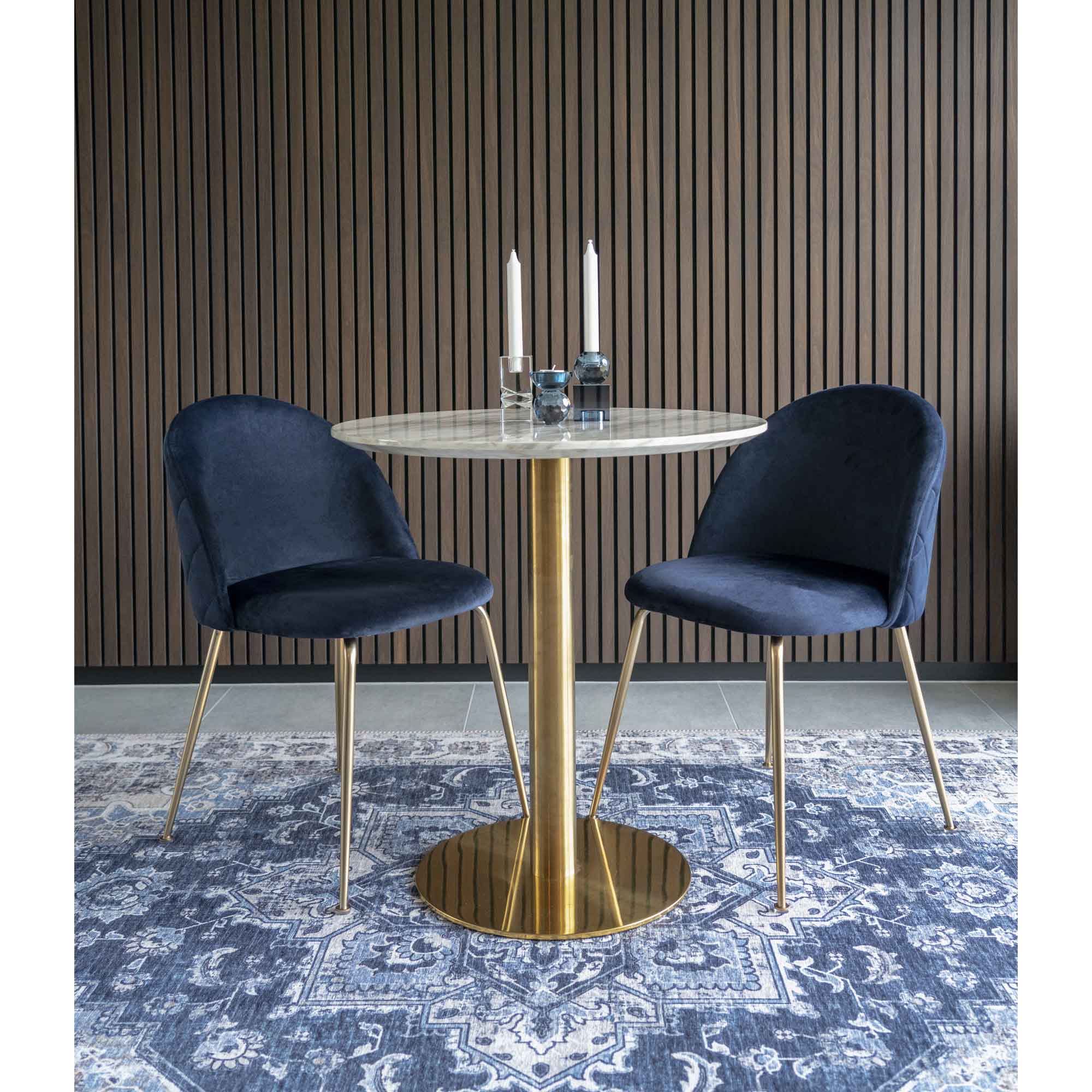 Table Bolzano marbre laiton en situation décor sombre chaises velours bleu