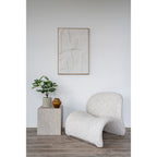 Tableau Madeline blanc accroché au-dessus d'un fauteuil en bouclé clair et d'une table cube effet marbre