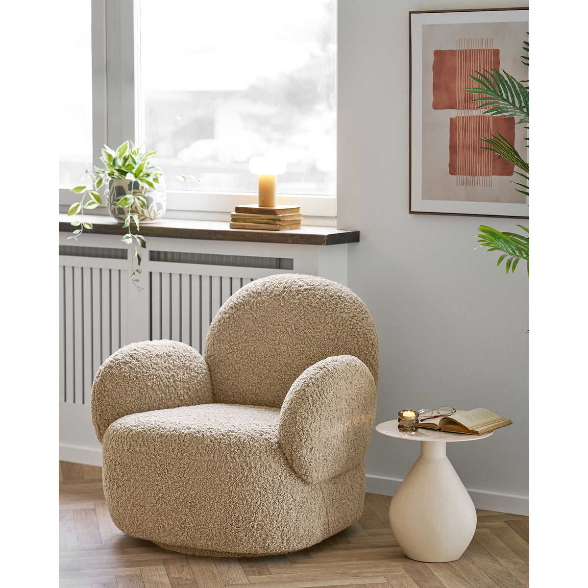 Coin lecture avec un fauteuil bouclé et le tableau Mina N°2 accroché au-dessus d'une table d'appoint