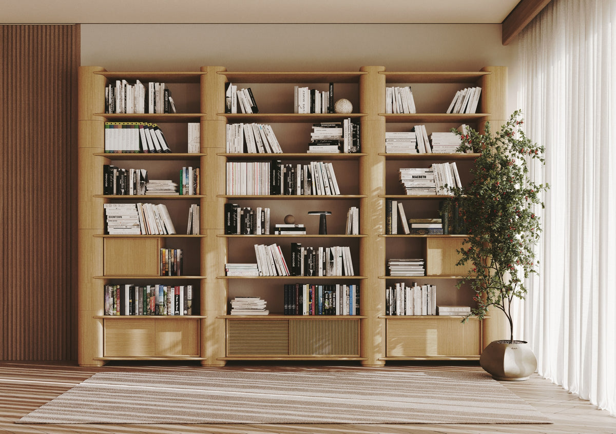 Bibliothèque Path en chêne naturel garnie de livres dans un salon lumineux