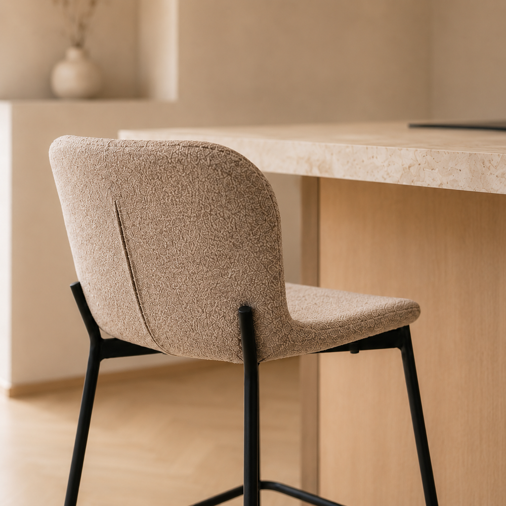 Gros plan sur le dossier d'un tabouret de bar en tissu bouclé beige texturé et son piètement en métal noir mat