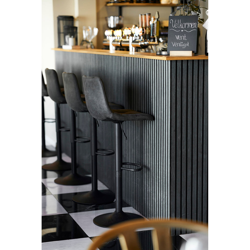 Tabourets de bar réglables Middelfart microfibre gris foncé alignés devant un comptoir de bar style restaurant