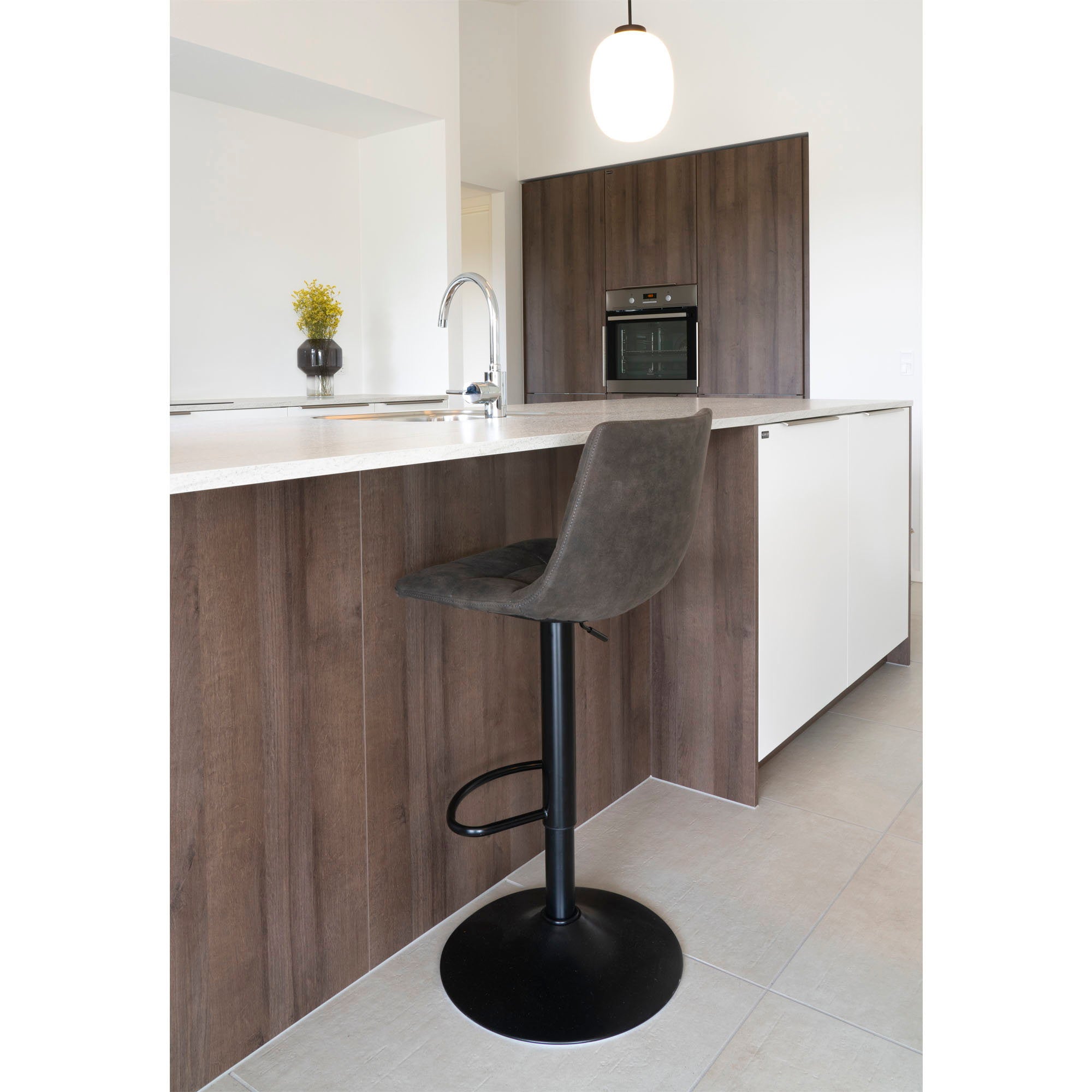 Tabouret de bar Middelfart gris foncé en situation devant un îlot de cuisine contemporain pied central noir