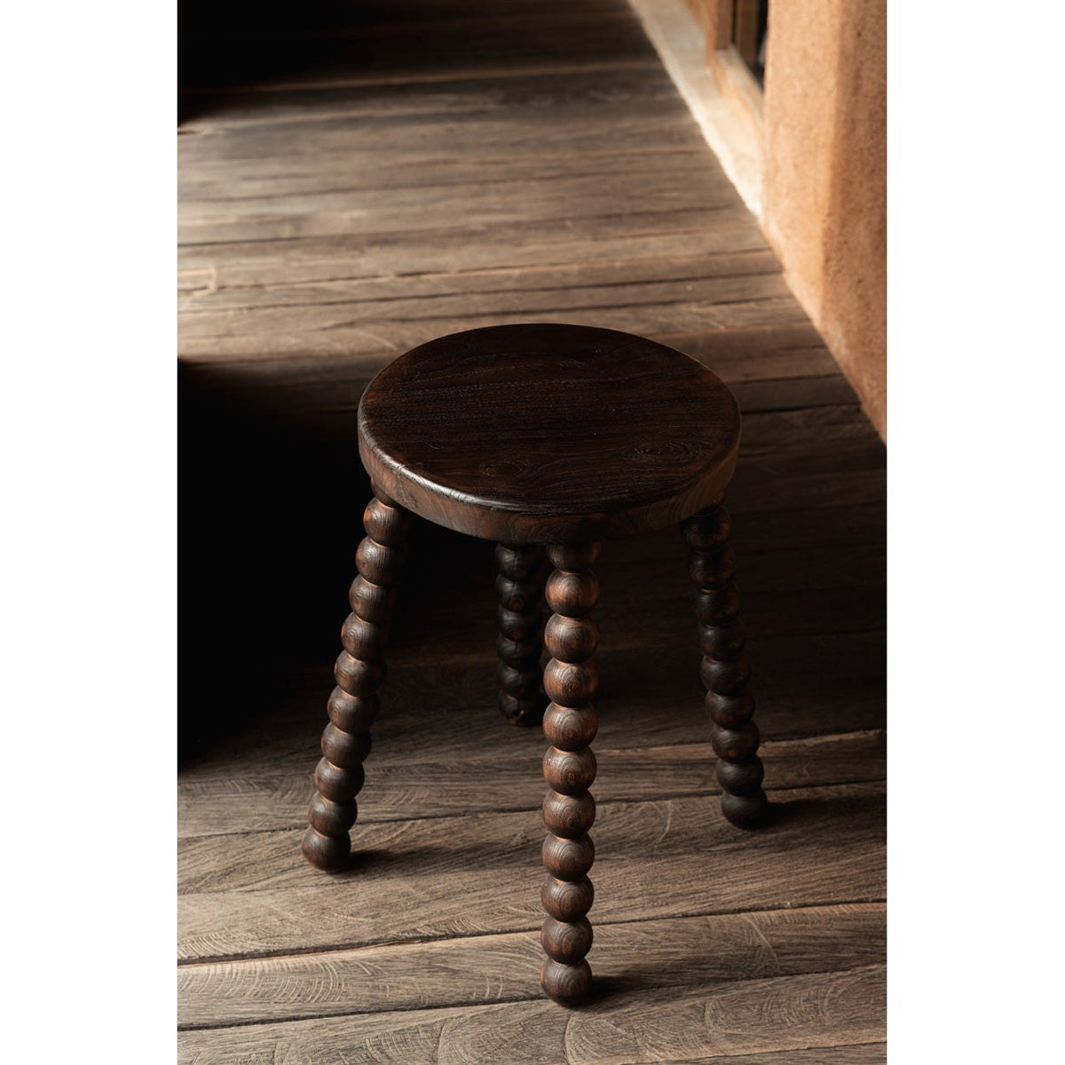 Tabouret Dango vu en plongée sur un plancher en bois patiné