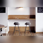 Deux tabourets de bar Hauteville sous un comptoir en bois dans un café