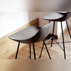 Coques en béton de deux tabourets de bar Hauteville vues de près au-dessus d'un parquet
