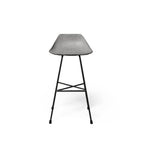 Tabouret de bar en béton Hauteville vu de face avec sa coque relevée à l'arrière et ses pieds en fer à béton reliés par un repose-pied