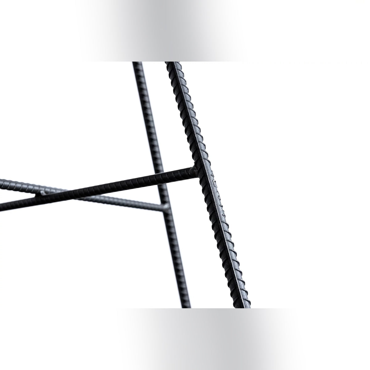 Pieds en fer à béton strié du tabouret de bar Hauteville reliés par des entretoises en croix