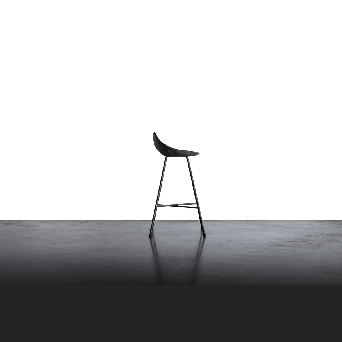 Tabouret de bar Hauteville vu de profil avec le bord arrière relevé de sa coque en béton