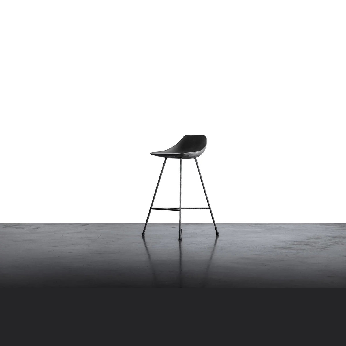 Tabouret de bar Hauteville vu de trois quarts sur un sol en béton lissé