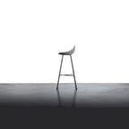 Tabouret de bar en béton Hauteville vu de profil sur un sol en béton lissé