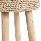 Détail du bord de l'assise en raphia et du haut des pieds en teck du tabouret Raffia