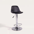Tabouret de bar Trondheim en simili cuir noir vu de trois quarts sur fond clair, pied chromé réglable et repose-pieds