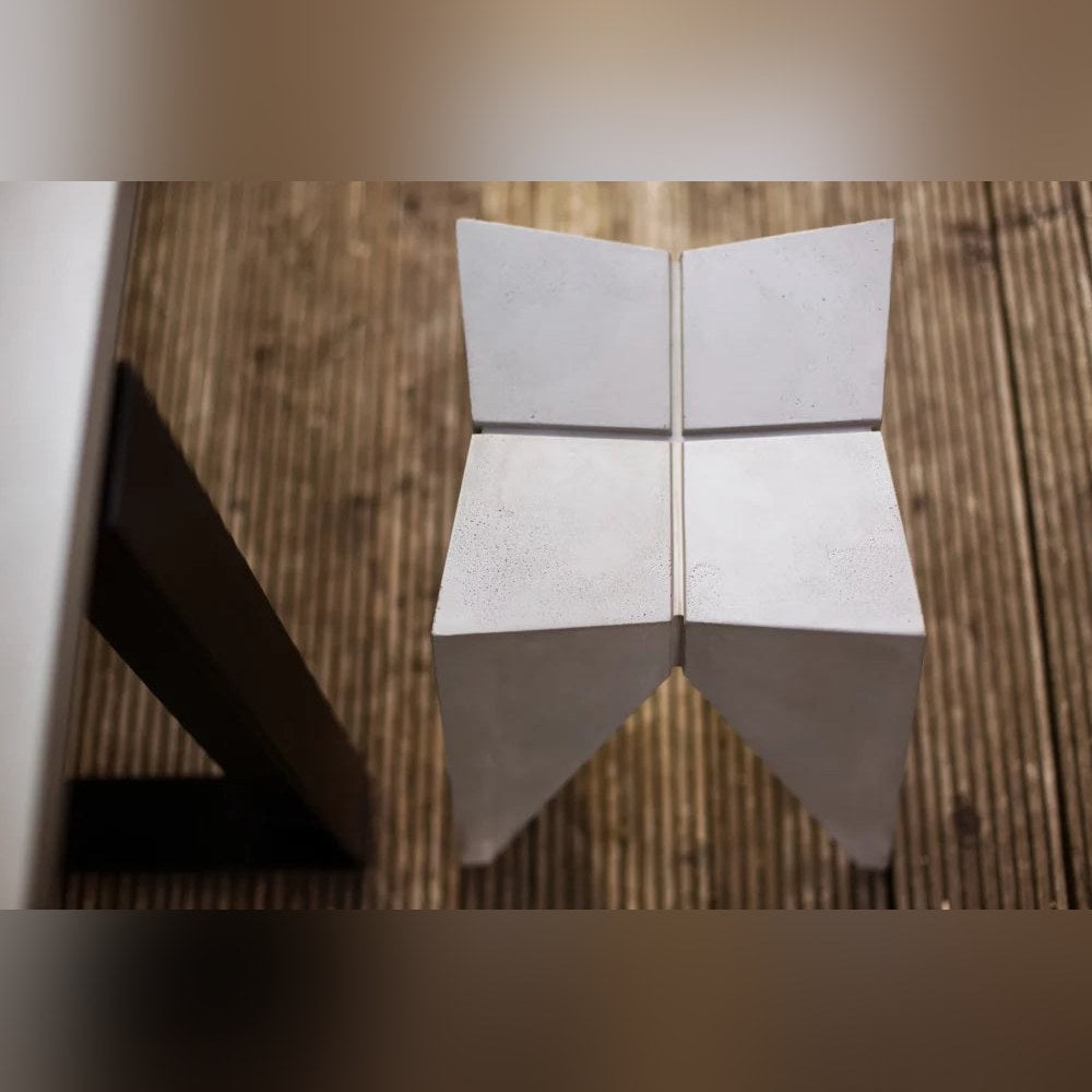 Tabouret Bridge en béton vu de dessus sur une terrasse en lames de bois