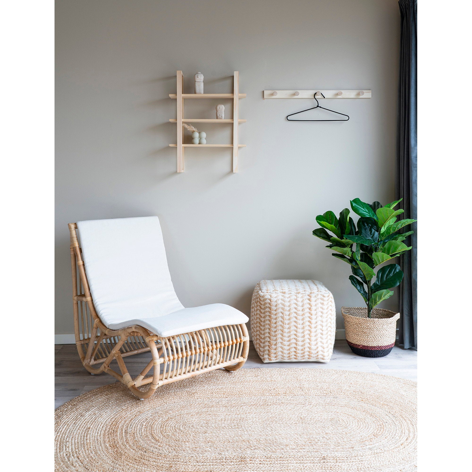 Tapis Bombay jute ovale naturel salon bohème avec chaise rotin et pouf blanc tressé